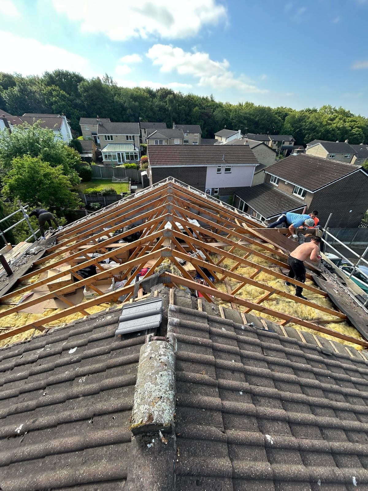 Old roof stripped back to bare rafters before a new pitched roof is installed