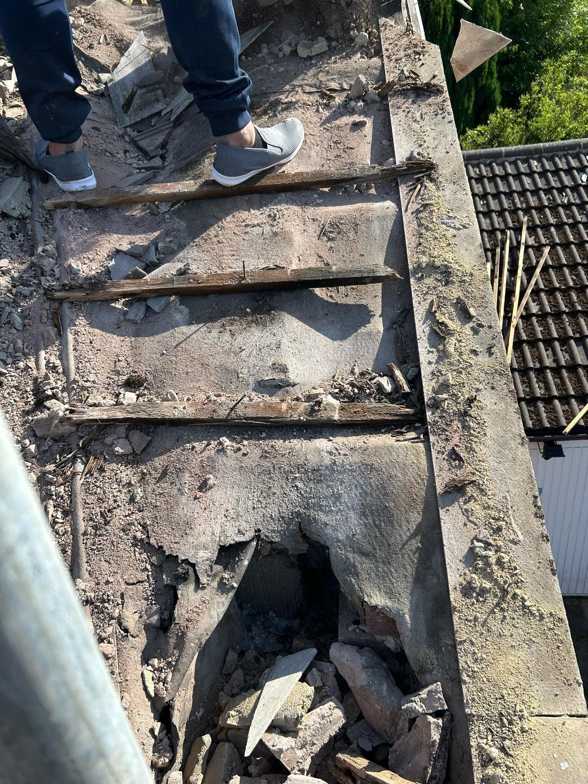 Failed roof covering stripped back to reveal water damage as part of a leaking roof repair